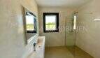 Modern bathroom of the Campos finca with walk-in shower, integrated sink and natural stone design