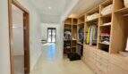 Spacious dressing room with light wood cabinets, open shelves and drawers in high-quality finca in Campos