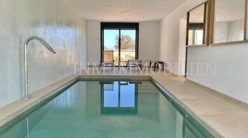 Modern indoor pool of the finca in Campos with water inlet, panoramic windows and mirror wall