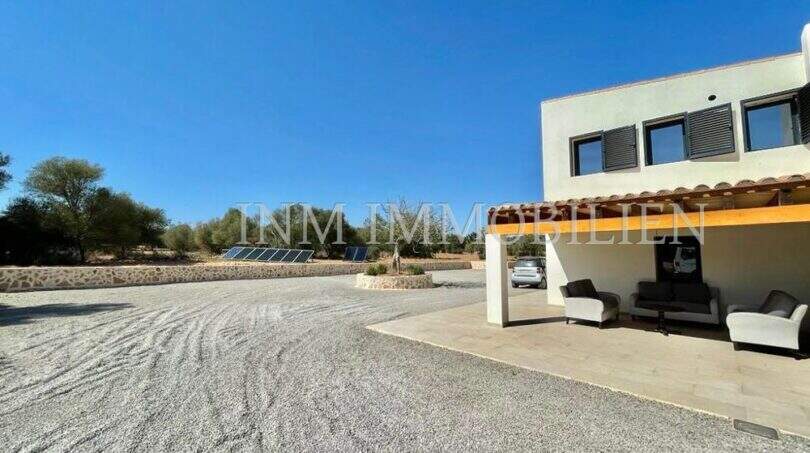 Extensive gravel driveway of a modern finca in Campos with covered terrace and solar system.