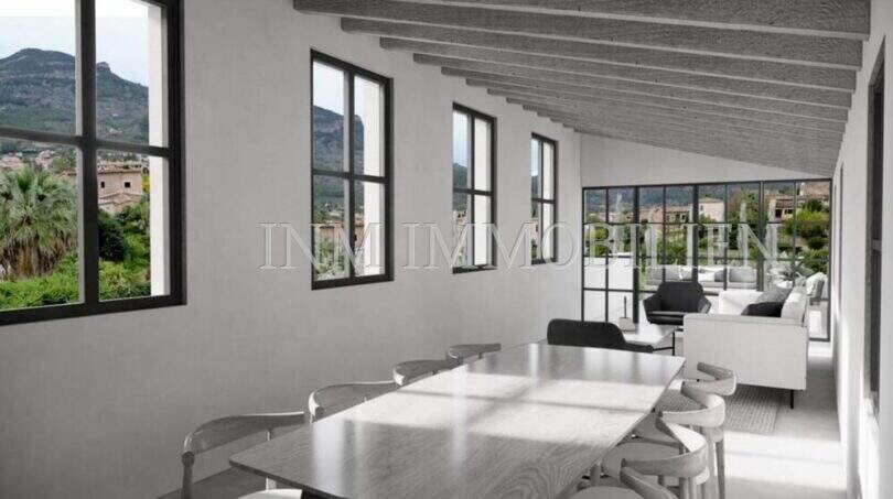 Zona de estar luminosa con techo de vigas, grandes ventanas y vistas panorámicas al Valle de Sóller, mobiliario moderno