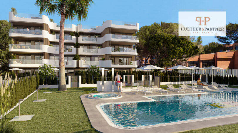 Außenansicht Neubauwohnanlage in Cala Ratjada mit Pool, Liegebereich und modernen Balkonen, umgeben von Grünflächen.