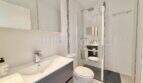 Modernes Badezimmer mit Waschtisch, WC und Glasdusche im Penthouse Cala Pi