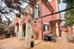 Außenansicht: Gepflegtes rotes Reiheneckhaus mit überdachter Terrasse, Gartenmöbeln und Bepflanzung in Pollença.