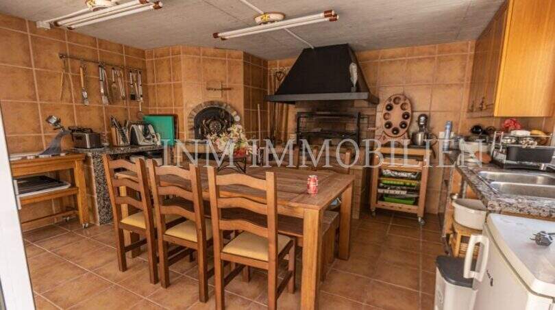 Rustikale Küche der Villa in Marratxí mit Holztisch, Stühlen, Kamin und traditionellem Holzofen.
