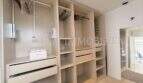 Begehbarer Kleiderschrank mit Hängeleisten, Schubladen und Regalen im Penthouse Cala Pi