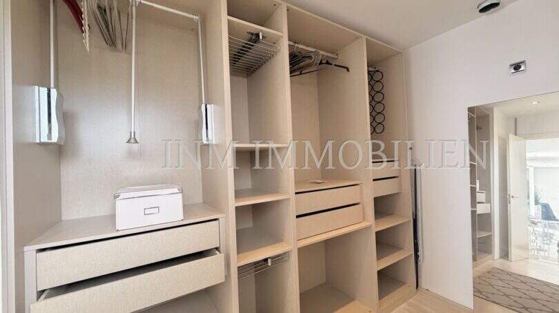 Begehbarer Kleiderschrank mit Hängeleisten, Schubladen und Regalen im Penthouse Cala Pi