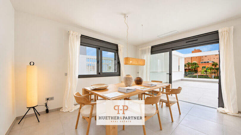 Helles Esszimmer im Penthouse Colonia de Sant Jordi mit Holztisch, Designlampe und Zugang zur Dachterrasse