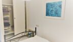 Helles Schlafzimmer der Mietwohnung in Cala Ratjada mit Doppelbett, Einbauschrank und blauem Kunstwerk.
