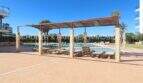 Poolbereich mit Pergola und Sonnenliegen der Neubau-Wohnanlage Residencial Tamarell in Sa Coma