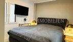 Elegant bedroom with double bed, gold bedside lamps and TV in Palma designer apartment