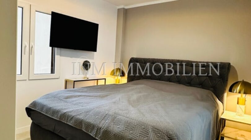 Elegant bedroom with double bed, gold bedside lamps and TV in Palma designer apartment