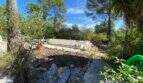 Abgedeckter Pool umgeben von mediterraner Vegetation und Pinien auf Finca in Algaida