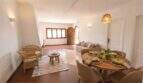 Luminosa sala-comedor de la finca mediterránea en Algaida con muebles de ratán, mesa de madera y suelo rústico de terracota.