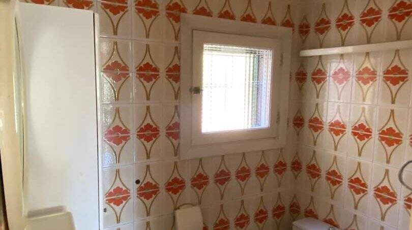 Baño retro de la finca en Algaida con azulejos estampados, inodoro y lavabo