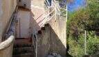 Außentreppe mit weißem Metallgeländer an mediterraner Finca in Algaida, renovierungsbedürftige Fassade