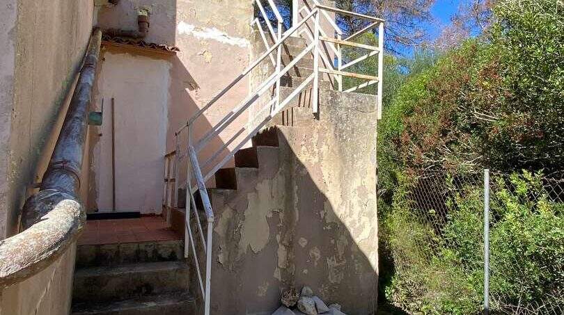 Außentreppe mit weißem Metallgeländer an mediterraner Finca in Algaida, renovierungsbedürftige Fassade