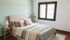 Helles Schlafzimmer mit mintgrüner Akzentwand, Terrakottaboden und natürlichen Materialien in mediterraner Finca Algaida