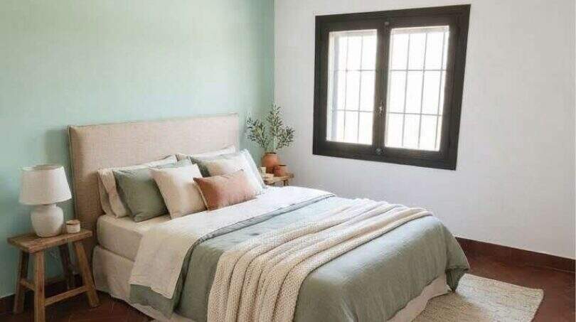 Helles Schlafzimmer mit mintgrüner Akzentwand, Terrakottaboden und natürlichen Materialien in mediterraner Finca Algaida