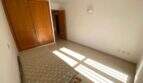 Helles Schlafzimmer der Ruheoase in Porto Cristo mit Einbauschrank aus Holz und Fliesenboden.