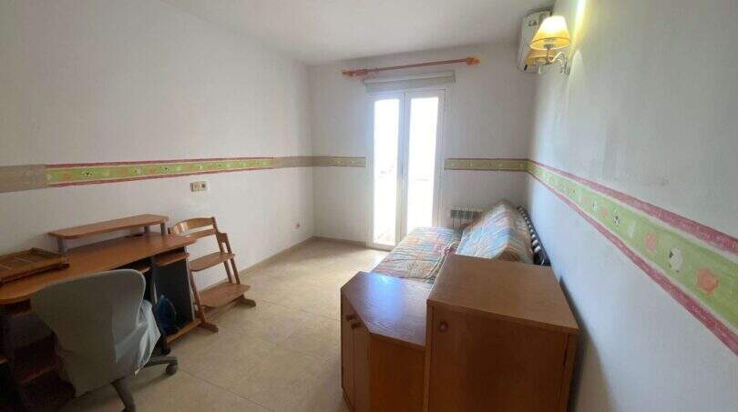 Helles Kinderzimmer mit Schreibtisch, Einzelbett, Wandbordüre und Balkonzugang in Ruheoase Porto Cristo.
