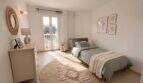 Helles Schlafzimmer der Ruheoase in Porto Cristo mit Einzelbett, Balkon, Rundteppich und natürlicher Dekoration.