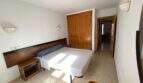 Helles Schlafzimmer der Ruheoase in Porto Cristo mit Doppelbett, Holzschrank und modernen Wandleuchten.