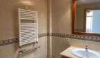 Helles Badezimmer mit Bidet, WC, Holzwaschtisch, Spiegel und Handtuchheizkörper in Ruheoase Porto Cristo