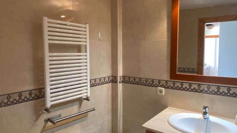 Helles Badezimmer mit Bidet, WC, Holzwaschtisch, Spiegel und Handtuchheizkörper in Ruheoase Porto Cristo
