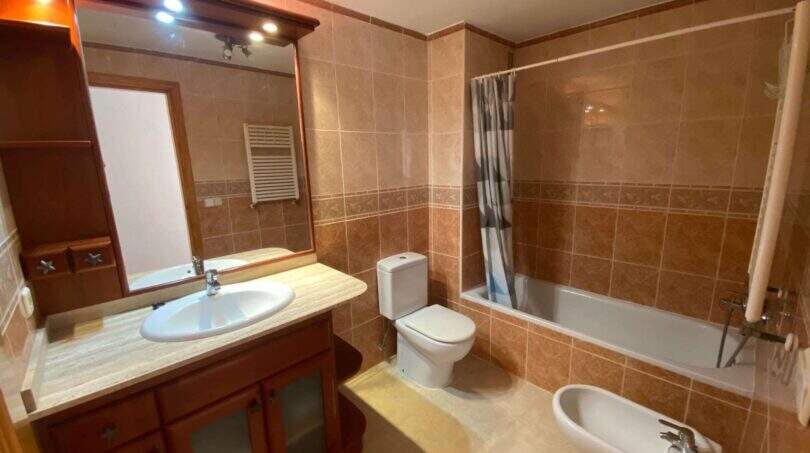 Badezimmer der Ruheoase in Porto Cristo mit Badewanne, WC, Bidet und Holzwaschtisch mit Spiegel.