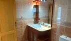 Helles Badezimmer mit Bidet, WC, Holzwaschtisch und beleuchtetem Spiegel in der Ruheoase Porto Cristo.