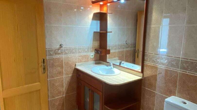 Helles Badezimmer mit Bidet, WC, Holzwaschtisch und beleuchtetem Spiegel in der Ruheoase Porto Cristo.