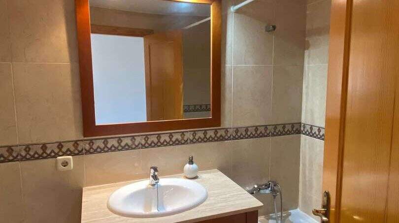 Badezimmer der Ruheoase in Porto Cristo mit Holzwaschtisch, Spiegel, Badewanne und Bidet.