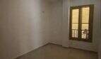 Leeres Zimmer mit Holzfenster und glänzendem Fliesenboden in Hafenwohnung Porto Cristo
