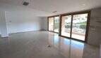 Helles, leeres Wohnzimmer mit Marmorböden und Balkon mit Meerblick in exklusiver Hafenwohnung Porto Cristo