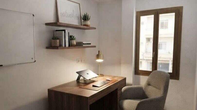 Modernes Arbeitszimmer mit Holzschreibtisch, Laptop, Wandregalen und Fenster in Hafenwohnung Porto Cristo