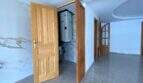 Flur der Hafenwohnung Porto Cristo mit Holztüren, Marmorboden und sichtbarem Technikraum mit Warmwasserspeicher