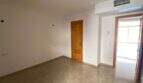 Leerer Wohnraum mit Marmorboden, Holztüren und Zugang zur Terrasse in Hafenwohnung Porto Cristo