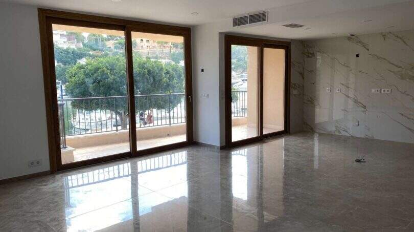 Helles Wohnzimmer mit Marmorböden, Panoramafenstern und Balkon mit Hafenblick in Porto Cristo