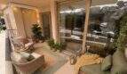 Gemütliche Balkonterrasse der Hafenwohnung Porto Cristo mit Rattanmöbeln, Pflanzen und Lichterketten
