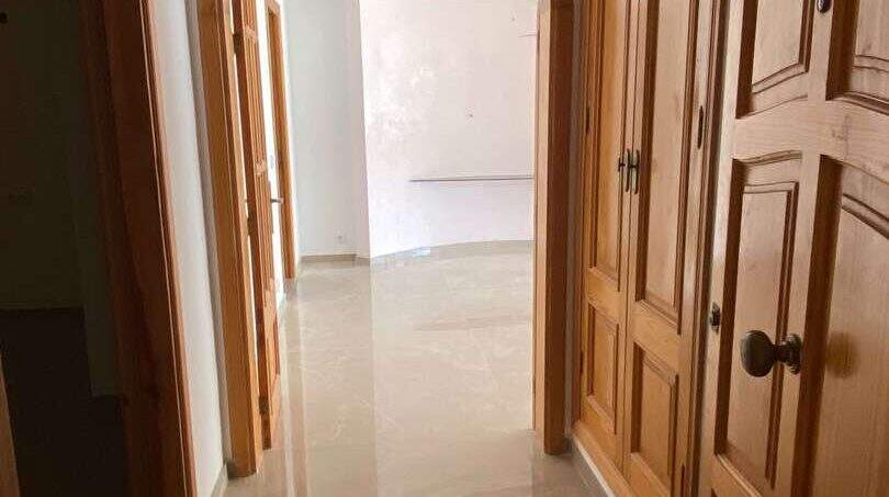 Eleganter Flur mit Rundbogen, Holztüren und Marmorboden in exklusiver Hafenwohnung Porto Cristo