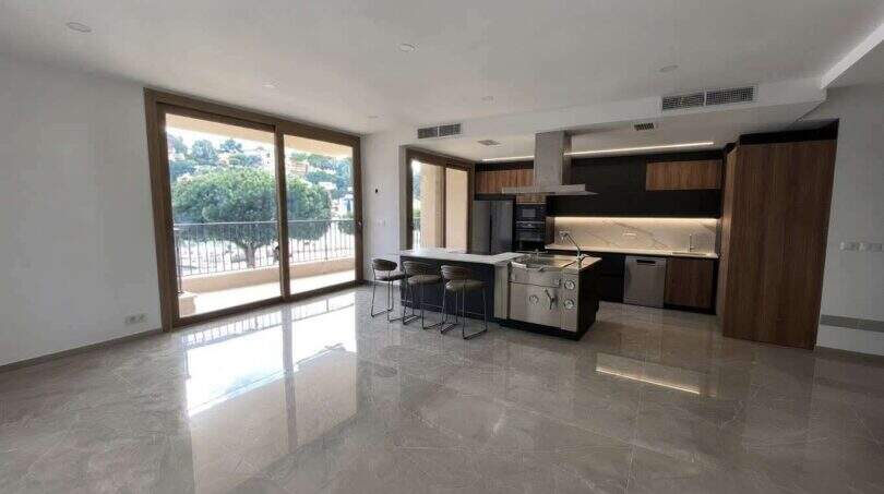 Offener Wohn-Küchenbereich mit Marmorboden, Kücheninsel und Balkon mit Meerblick in Porto Cristo