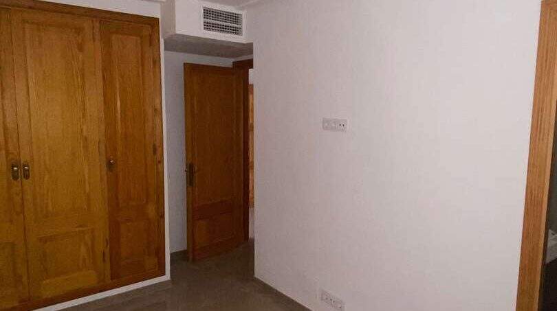 Leeres Schlafzimmer mit Einbauschrank, Marmorboden und Klimaanlage in Hafenwohnung Porto Cristo