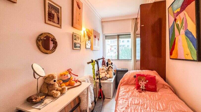 Kleines Kinderzimmer mit Einzelbett, Teddybären, Wandbildern und Fenster in strandnaher Wohnung in Palma