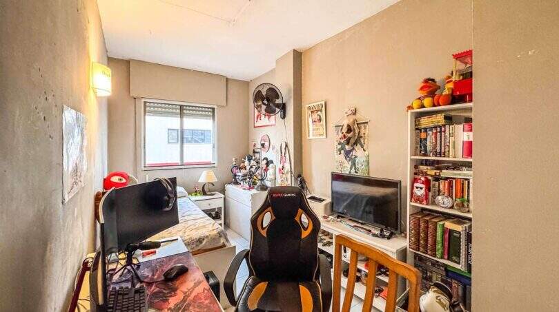 Jugendzimmer mit Gaming-Stuhl, Schreibtisch, TV und Bücherregal in strandnaher Wohnung in Palma de Mallorca.