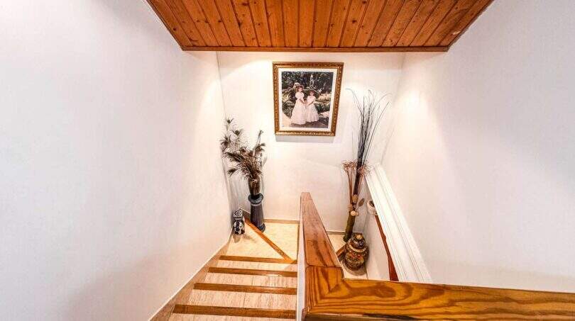 Helle Treppenhaus mit Holzgeländer, Marmorstufen und Holzdecke in strandnaher Wohnung Palma de Mallorca