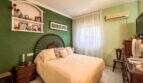 Schlafzimmer der Wohnung in Palma mit grüner Akzentwand, Doppelbett und Klimaanlage