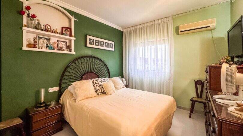 Schlafzimmer der Wohnung in Palma mit grüner Akzentwand, Doppelbett und Klimaanlage
