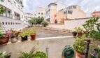 Terrasse mit Topfpflanzen und Blick auf Innenhof, umgeben von mehrstöckigen Wohngebäuden in Palma de Mallorca.