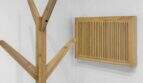 Holzgarderobe im Baumdesign und Holzlüftungsgitter an weißer Wand im modernen Stadthaus Felanitx